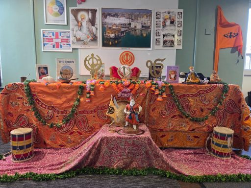 A vibrant altar decorated with orange drapes, flowers, and religious symbols.