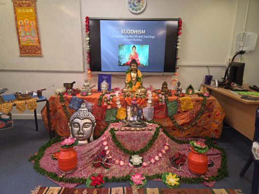 A vibrant altar with flowers, statues, and offerings for a cultural celebration.